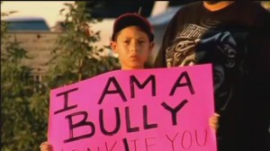 Kid holding I am a Bully sign.