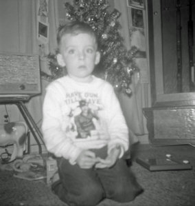 Blurry picture of me sitting in front of a christmas tree.