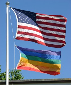 An American and a gay pride flag waving in the wind