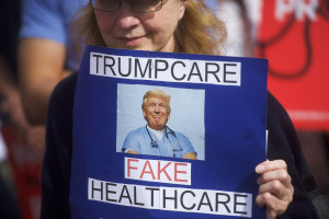 A demonstrator holds a sign reading "Trumpcare - Fake Healthcare" during a health care rally at Thomas Paine Plaza on February 25, 2017 in Philadelphia, Pennsylvania.  Rallies are being held across the country in support of the Affordable Health Care Act.  (Photo by Mark Makela/Getty Images)