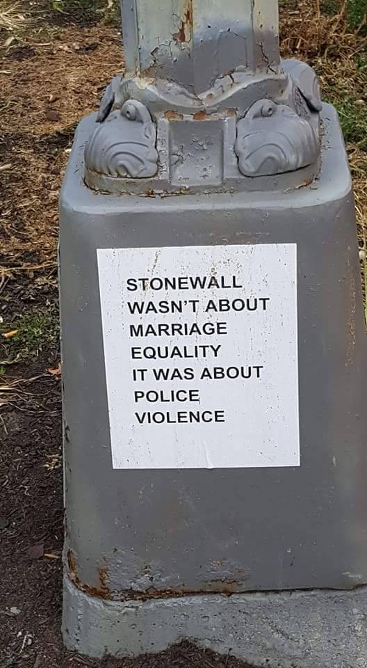 Sticker on the base of a light pole reads, “Stonewall wasn't about Marriage Equality, it was about police violence.”